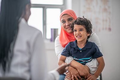 Woman holding child on her lap at a doctor's appointment